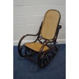 A BENTWOOD STAINED BEECH ROCKING CHAIR with a cane seat and back