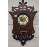 AN EARLY 20TH CENTURY CARVED WALL CLOCK, enamel dial with Arabic numerals, height 75cm