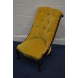 A VICTORIAN MAHOGANY SCROLLED BACK NURSING CHAIR, covered in buttoned mustard yellow upholstery,