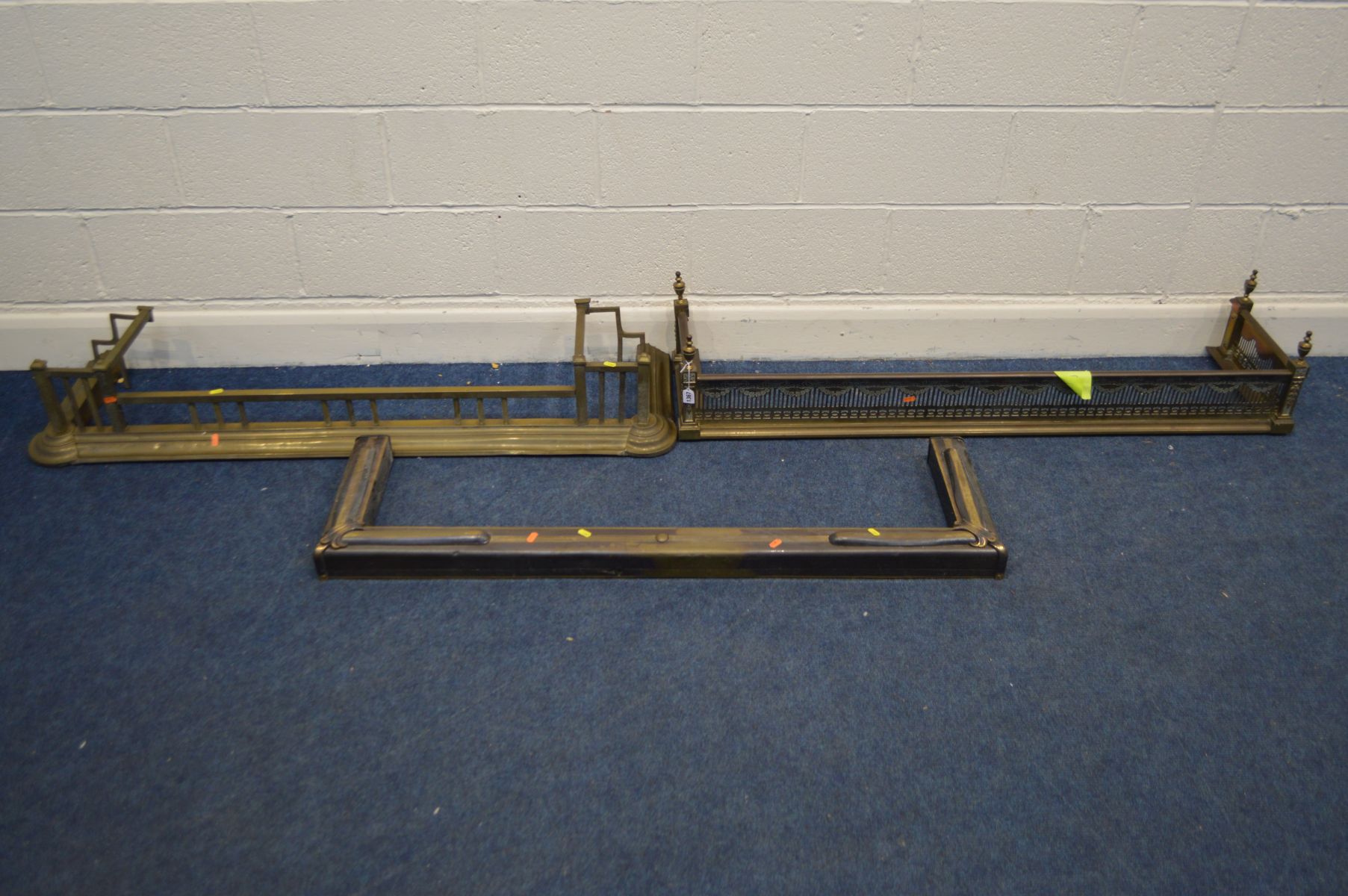 AN EARLY 20TH CENTURY BRASS FENDER, width 136cm, together with two other fenders (3)