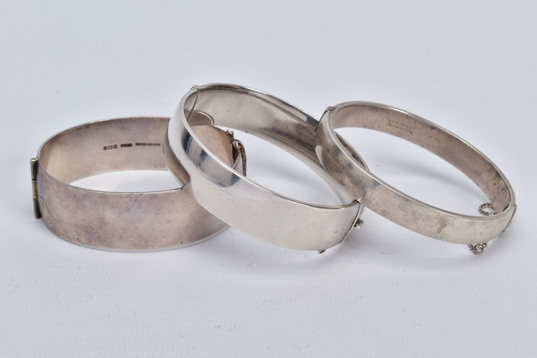 THREE SILVER HINGED BANGLES, the first a wide bangle with a foliate engrave design, push pin clasp - Image 2 of 3