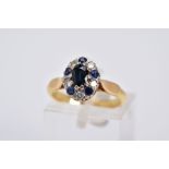 A SAPPHIRE AND DIAMOND CLUSTER RING, of tiered design set with a central oval cut sapphire, within a