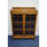 A MID 20TH CENTURY OAK GLAZED DOUBLE DOOR BOOKCASE, on bun feet, width 86cm x depth 27cm x height