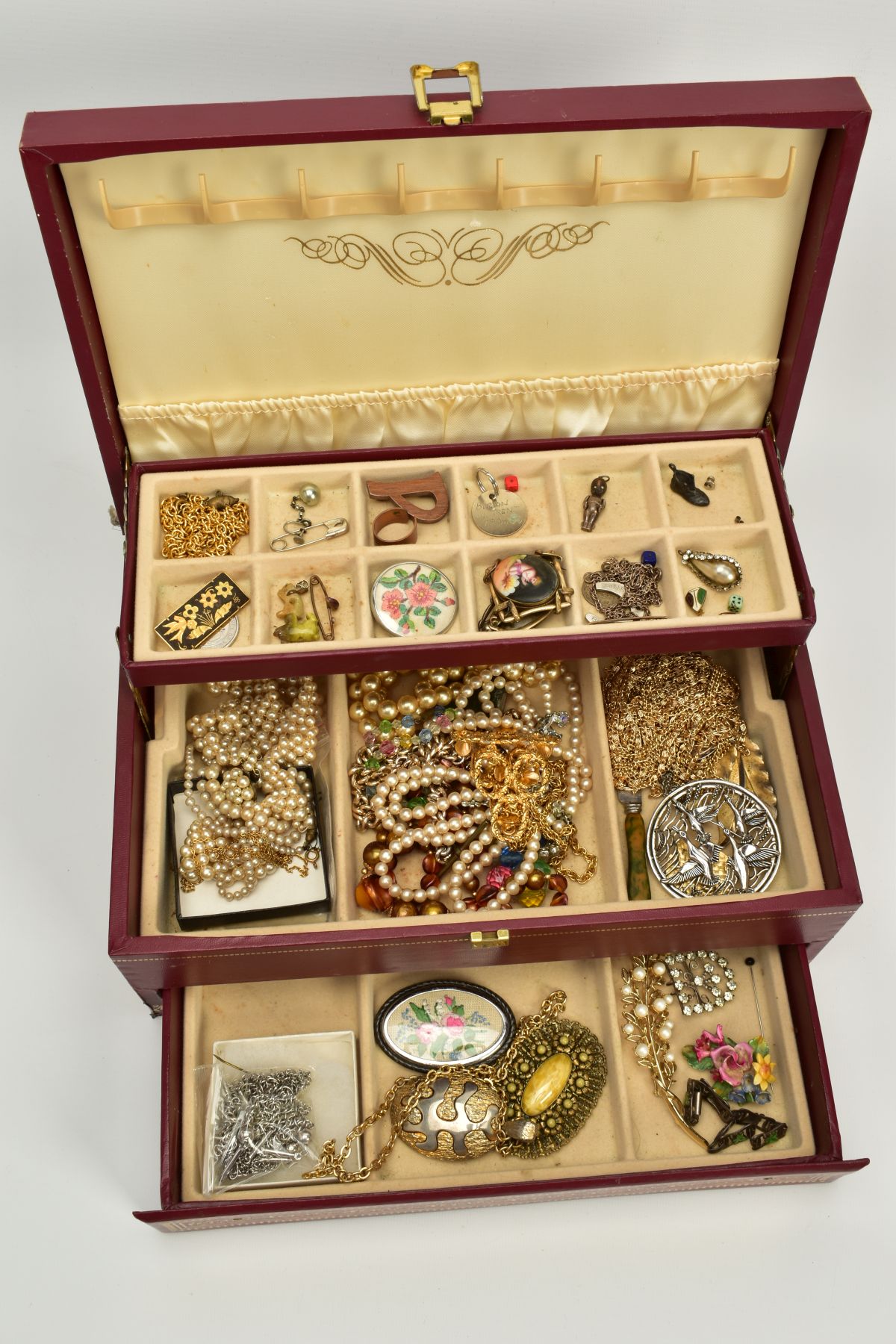 A JEWELLERY BOX WITH COSTUME JEWELLERY, the three tiered burgundy and gold trim jewellery box