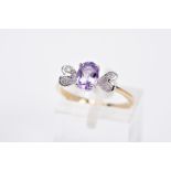 A 9CT GOLD AMETHYST AND DIAMOND RING, designed with a claw set, oval cut amethyst, with heart shaped