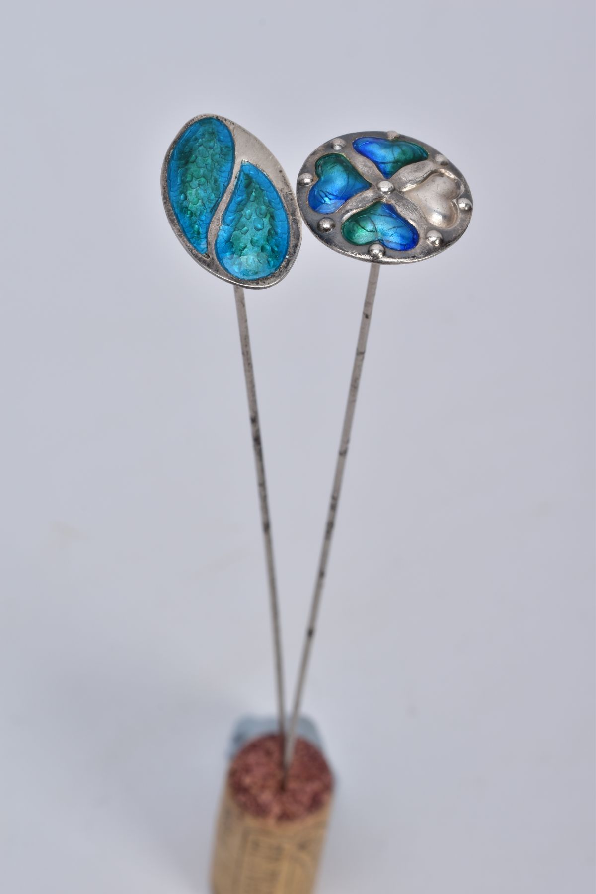 TWO SILVER ARTS AND CRAFTS ENAMEL HAT PINS, the first of circular form, with blue and green enamel