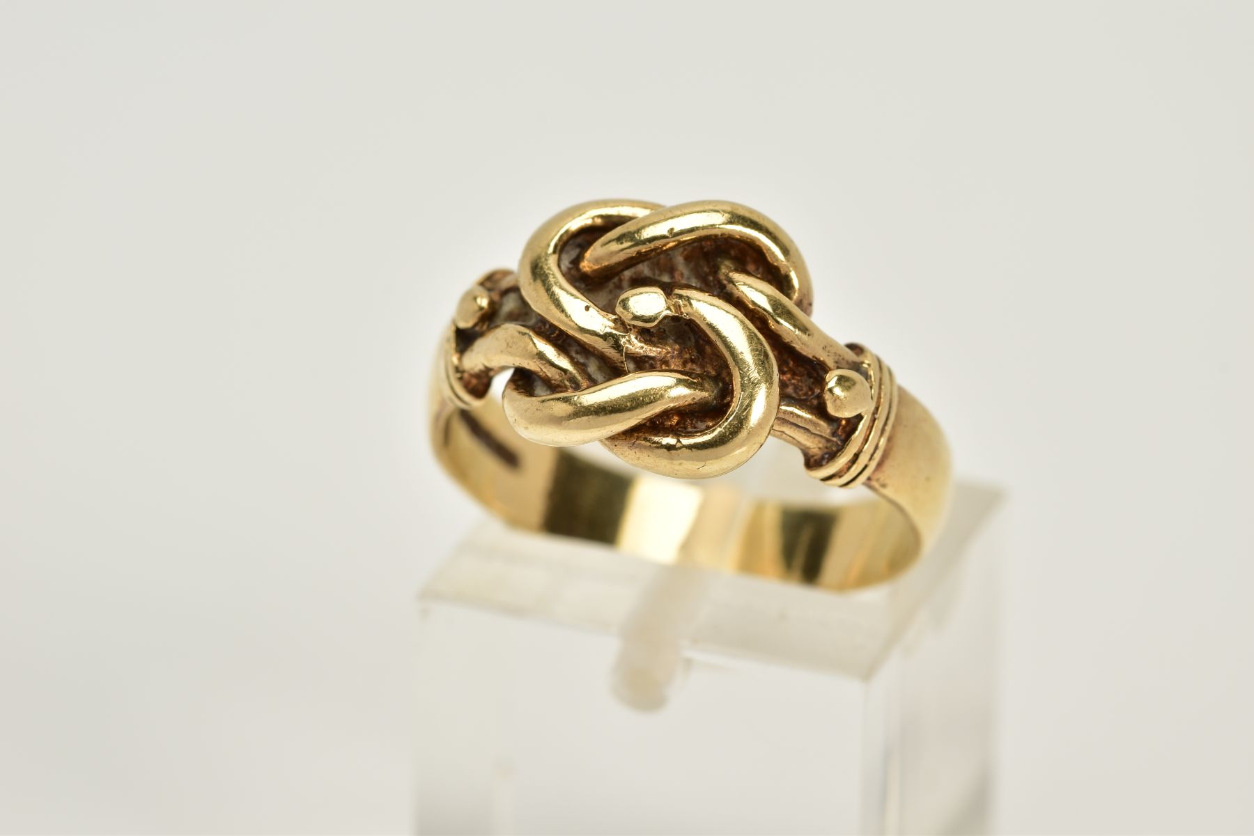A 9CT GOLD KNOT RING, with a plain polished wide band, hallmarked 9ct gold London, ring size O,