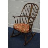 AN ERCOL GOLDEN DAWN ASH CHAIRMAKERS WINDSOR ROCKING CHAIR, on a crinoline stretcher, with a