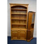 A TALL PINE OPEN BOOKCASE, with four fixed shelves, above two drawers and double cupboard doors,