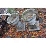A PAIR OF COMPOSITE GARDEN URNS, with square flutted bases 41cm in diameter and 63cm high