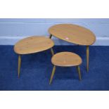 AN ERCOL BLONDE ELM NEST OF THREE PEBBLE TABLES, model 354, on cylindrical out splayed legs, largest