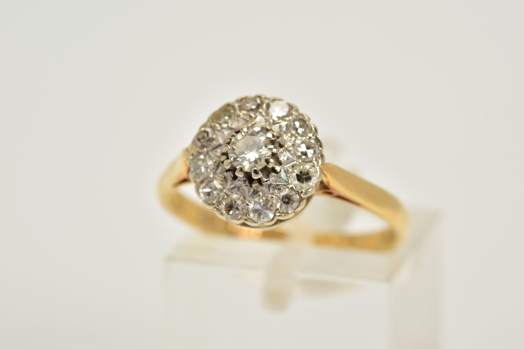 AN 18CT GOLD DIAMOND CLUSTER RING, the tiered cluster set with a central round brilliant cut