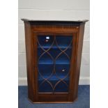 A GEORGIAN MAHOGANY AND CROSSBANDED ASTRAGAL GLAZED SINGLE DOOR CORNER CUPBOARD, with a painted
