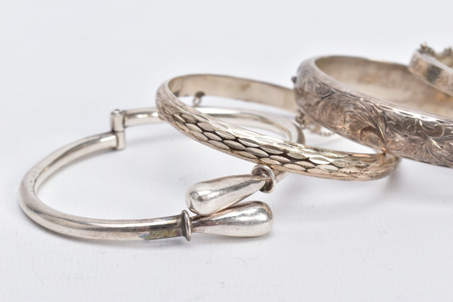 FOUR SILVER BANGLES, such as a floral engraved hinged bangle, with broken safety chain, hallmarked - Image 2 of 3