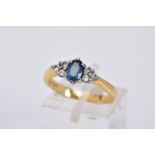 AN 18CT GOLD SAPPHIRE AND DIAMOND RING, designed with a central oval cut sapphire flanked by three