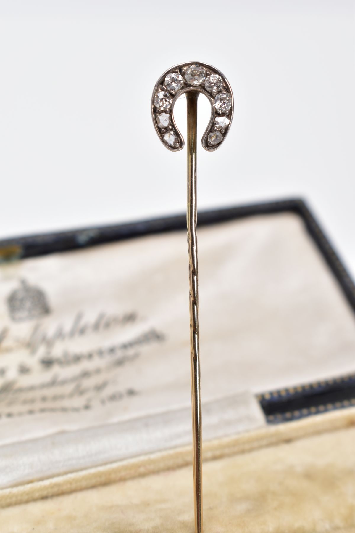 AN EDWARDIAN DIAMOND STICK PIN, the yellow metal pin in the form of a horse shoe, set with five - Image 2 of 3