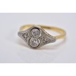 AN EARLY 20TH CENTURY DIAMOND RING, of art deco style, set with two central round brilliant cut