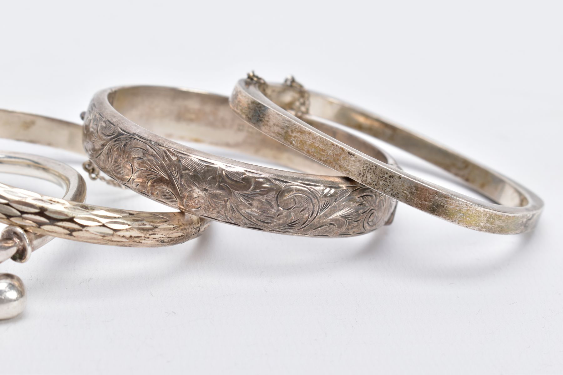 FOUR SILVER BANGLES, such as a floral engraved hinged bangle, with broken safety chain, hallmarked - Image 3 of 3