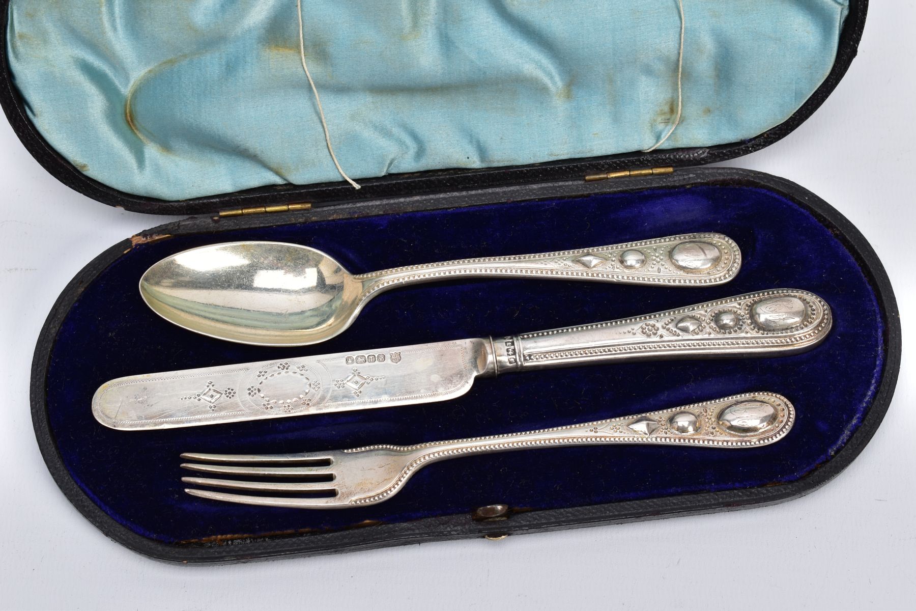 A CASED SET OF SILVER CUTLERY, to include a three-piece set of floral engraved beaded edge pattern