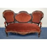 A VICTORIAN ROSEWOOD TRIPPLE BACK SOFA, with open armrests, on cabriole front legs and brass