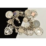 A SILVER CHARM BRACELET, suspending twenty-three charms, such as coins, fobs, a dog, crocodile,