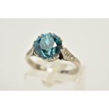 AN 18CT WHITE GOLD BLUE ZIRCON AND DIAMOND RING, centring on a circular but blue zircon measuring