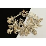 A CHARM BRACELET, suspending twenty five charms in forms such as a bird in a cage, ballerina