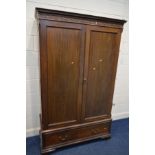 A GEORGIAN MAHOGANY PANELLED DOUBLE DOOR WARDROBE, Heal and Son, London label to interior, carved