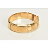 A 9CT GOLD HINGED OVAL BANGLE, half engraved (a.f. this bangle is damaged in several places)