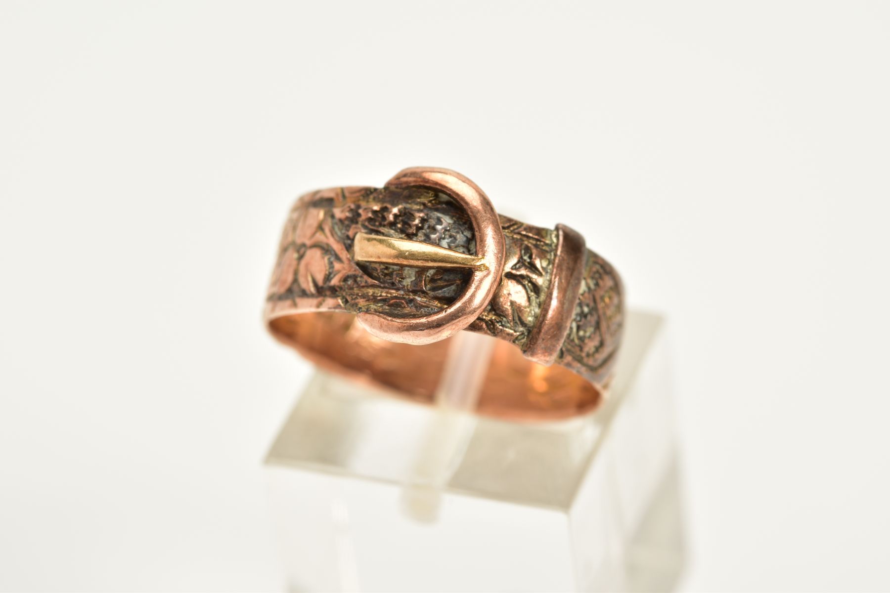 AN EARLY 20TH CENTURY 9CT GOLD RING, of belt and buckle form with floral engraved detail, hallmarked