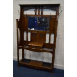 AN EARLY 20TH CENTURY ARTS AND CRAFTS OAK HALL STAND, with winged sides, eight coat hooks, central