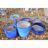 SIX GLAZED GARDEN PLANT POTS (largest being 45cm diameter and 50cm high) and a similar bird bath