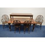 AN EDWARDIAN WALNUT WIND OUT DINING TABLE, canted corner, one additional leaf, on fluted legs and