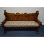A STAINED PINE SETTLE, with a floral squab cushion, width 210cm x width inner seat 184cm x depth