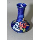 A SMALL MOORCROFT POTTERY VASE, 'Orchid' pattern on a blue glaze, Queen Mary paper label to base,