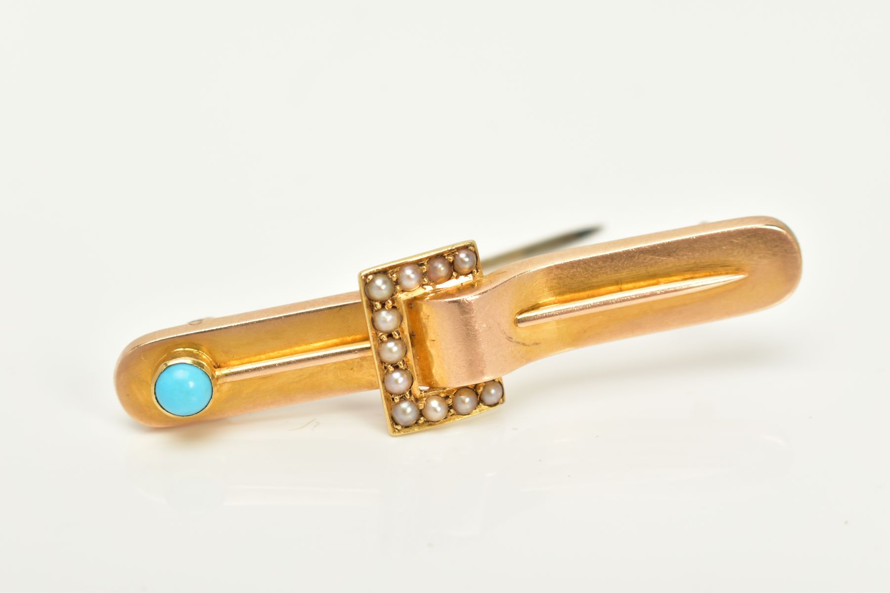 A YELLOW METAL BROOCH, in the form of a belt, set with split pearls and a turquoise cabochon, length