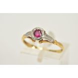 A YELLOW METAL RUBY RING, designed with a single circular cut ruby within a collet mount, textured