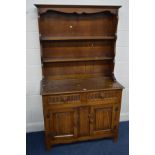 AN EARLY 20TH CENTURY OAK LINENFOLD DRESSER, with two drawers above two cupboard doors, labelled 'L.