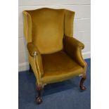 A GEORGIAN II STYLE WING BACK ARMCHAIR, on large mahogany ball and claw front legs, with casters,