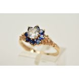 A 9CT GOLD CLUSTER RING, designed with a central circular cut colourless spinel, within a circular