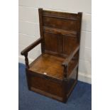 A GEORGIAN OAK SINGLE SEAT SETTLE, the panelled back with roundel decoration above open arm rests,