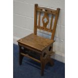 AN EARLY 20TH CENTURY OAK ARTS AND CRAFTS/GOTHIC METAMORPHIC LIBRARY CHAIR/STEPS with carved