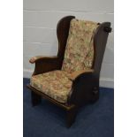 AN EARLY 20TH CENTURY ARTS AND CRAFTS OAK ARMCHAIR, with floral cushions