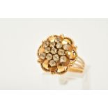 A YELLOW METAL CLUSTER RING, in the form of an openwork flower, set with circular cut colourless