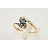 A 9CT GOLD SAPPHIRE AND DIAMOND RING, a cross over design, set with a central circular cut sapphire,