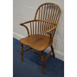 A 20TH CENTURY OAK AND ELM SPINDLE HOOP BACK WINDSOR ARMCHAIR, on turned legs united by a H