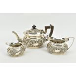 A SILVER THREE PIECE TEA SET, to include a floral embossed, flat based, wooden handled teapot, a