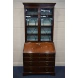 A GEORGE III MAHOGANY AND WALNUT CROSSBANDED BUREAU BOOKCASE, the top with an overhanging cornice,
