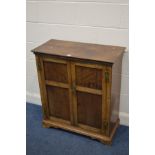 A GEORGIAN OAK TWO DOOR CUPBOARD, with panelled doors enclosing two fixed shelves on bracket feet