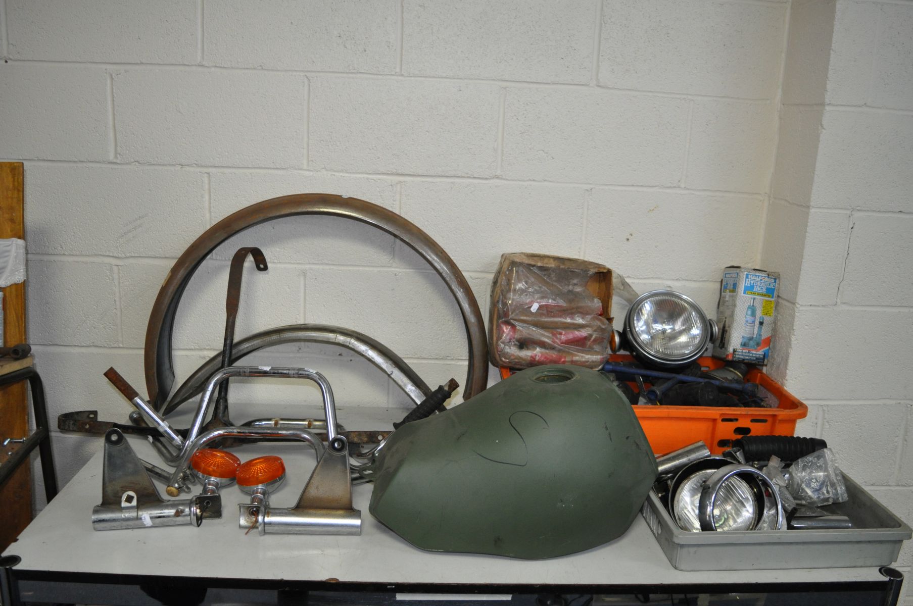 TWO TRAYS CONTAINING VINTAGE AUTOMOTIVE PARTS, including a motorbike fuel tank, mud guards, handle